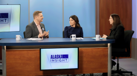 Kati Capozzi, Nick Moe, and Lori Townsend sit at a desk speaking with each other.