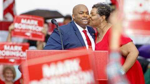 North Carolina Lt. Governor Mark Robinson gets a kiss from his wife, Yolanda Hill during a campaign rally announcing he is officially running for governor outside Ace Speedway in Elon, N.C. Saturday, April 22, 2023.
