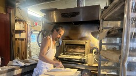 Jonathan Stevens, owner and baker of Hungry Ghost Bread in Northampton, Massachusetts, prepares dough for a country bread loaf to go in the oven.