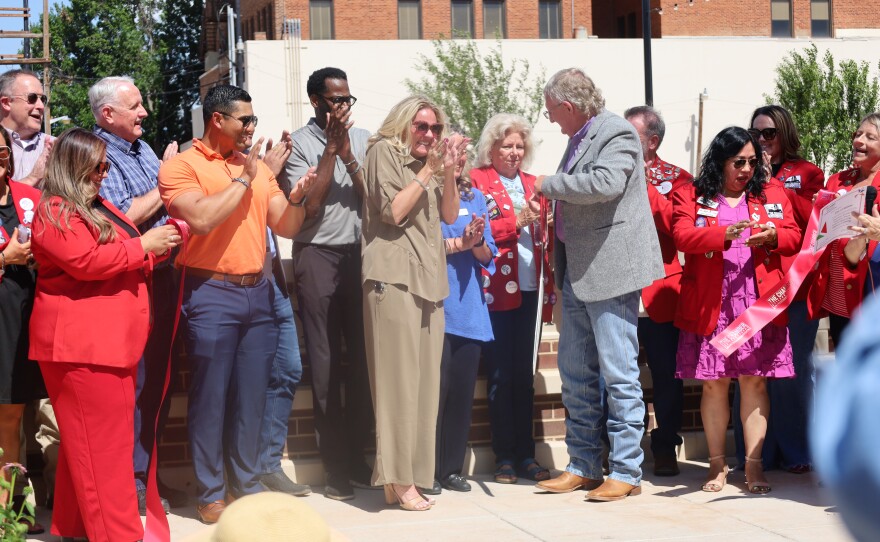 Kate Alvarez, Downtown Coordinator, joined by Mayor Hurt, red coats, Chamber of Abilene, and City Councilmen applaud after the ribbon cutting. Photo by Allison Diaz.