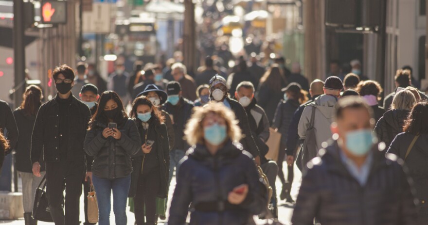 November 2020 - Crowd of people walking a New York City street wearing masks during COVID-19 pandemic.