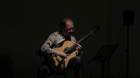 Guitarist Jamie Monck performing in a dark room