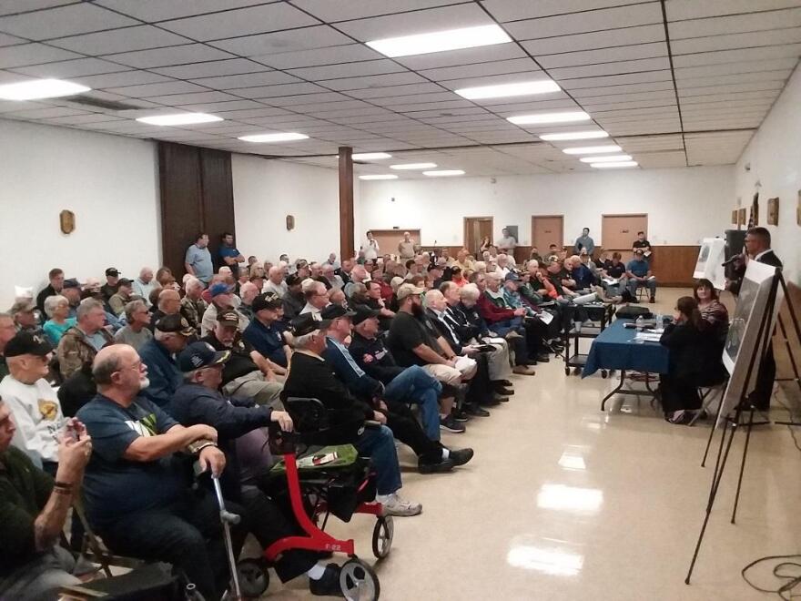 Guests listen to James Metcalfe, director of the Western New York National Cemetery, during a public meeting inside the Pembroke Community Center in Corfu Wednesday. CREDIT MICHAEL MROZIAK, WBFO