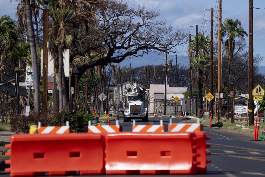 FILE - Burned cars and propane tanks with markings on them sit outside a house destroyed by wildfire, Friday, Dec. 8, 2023, in Lahaina, Hawaii. (AP Photo/Lindsey Wasson, File)