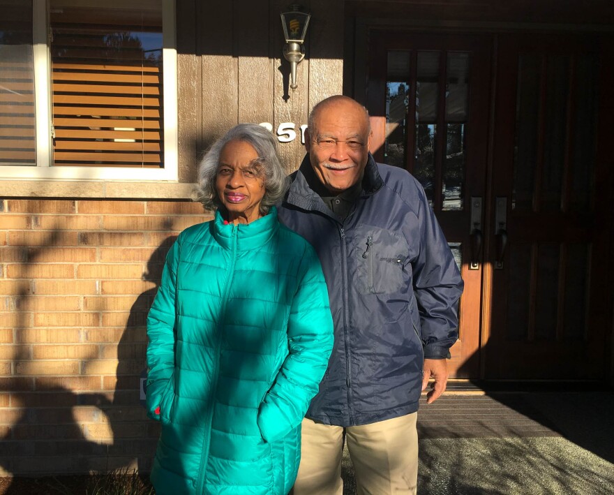 Violet and Norward Brooks in front of a house they struggled to buy due to discrimination.