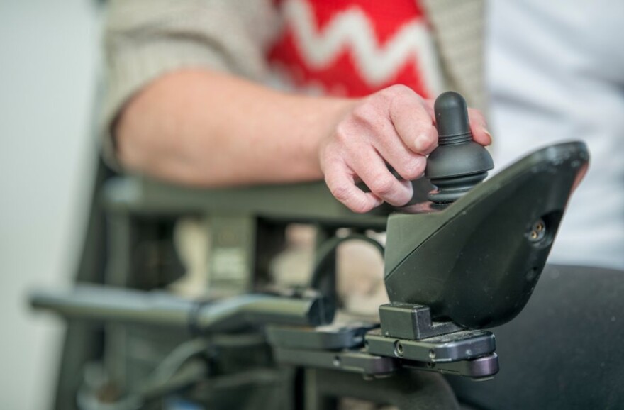 Hand reaching for a control stick for motorized wheelchair