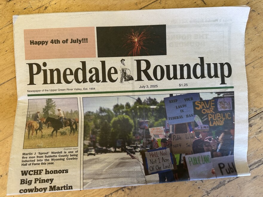 A photo of a newspaper called the 'Pinedale Roundup', featuring stories about protests and cowboys.