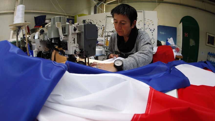 Michelle Houste sews a French flag at a factory near Lille, northern France on Thursday. There's been a surge in the demand for French flags since the Nov. 13 attacks in Paris.