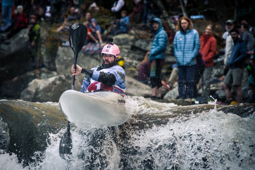 man in kayak going down rapid