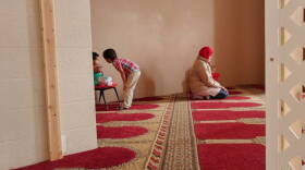 alia Mohamed prays before an interview at the Islamic Society of Columbus, Indiana, while her kids, 2-year-old Selma and 5-year-old Mohamed, play nearby.