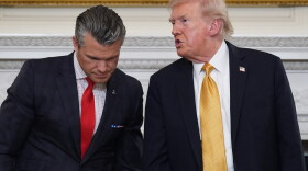 FILE - President Donald Trump talks with Defense Secretary Pete Hegseth after a roundtable on criminal cartels in the State Dining Room of the White House, Oct. 23, 2025, in Washington.