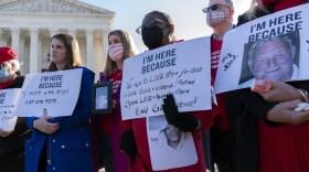 Gun violence survivors hold their banners during a rally Wednesday outside of the U.S. Supreme Court. The court heard arguments in a gun rights case that centers on New York's restrictive gun permit law.