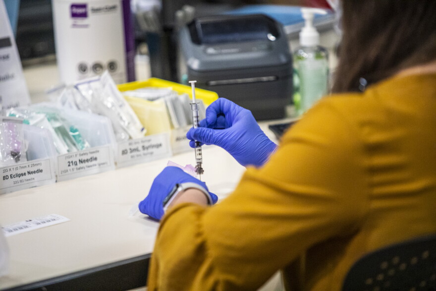 A healthcare worker prepares a Pfizer vaccine dose at a large-scale vaccination site at UNC's Friday Center in Chapel Hill Tuesday, Jan. 19 2021.