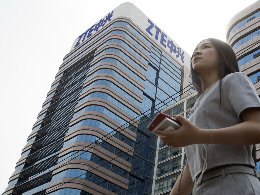 A woman passes by a ZTE building in Beijing, China shortly after President Trump tweeted about possibly reversing a ban on the tech giant in May.
