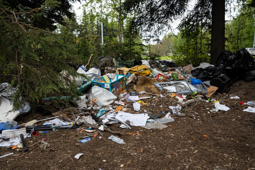Personal belongings and trash cover the ground at Lois Drive and Benson Boulevard on May 20, 2025.
