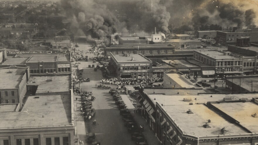 This archival photo shows crowds of people watching fires during the June 1, 1921, Tulsa Race Massacre.