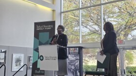 Burlinda Radney, president of the Historic Greenwood Main Street Program, speaking to an audience at the Greenwood Cultural Center during the launch of the Tulsa Housing Impact Fund on Nov. 19, 2025, as Housing Partnership Network President & CEO Robin Hughes looks on.