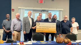 Officials hold a ceremonial check after receiving word of $16 million in state funding to help pay for a water treatment plant in Sturgis, KY