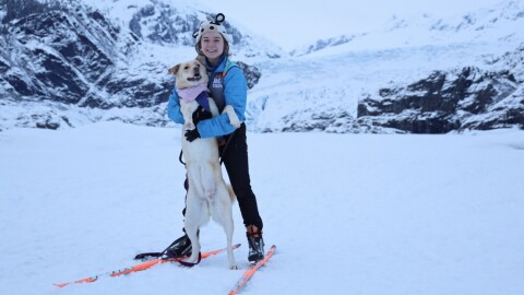 KTOO reporter Clarise Larson and her dog, Bloon, in front of the Mendenhall Glacier in February 2023.