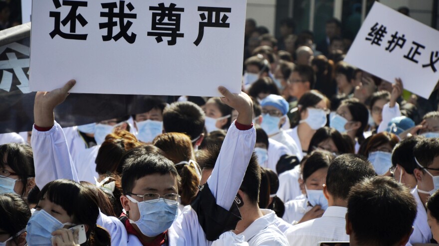 Hospital workers protest against attacks on medical workers outside the No. 1 People's Hospital in Wenling, in east China's Zhejiang province, on Oct. 28. The protest came after a man stabbed three doctors, killing one, three days earlier.