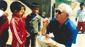 Ralph Munro, Washington's former secretary of state, blows bubbles with Vietnamese refugees. Gov. Dan Evans asked Munro to find out more about the refugees, so he went to Camp Pendleton in California in 1975.