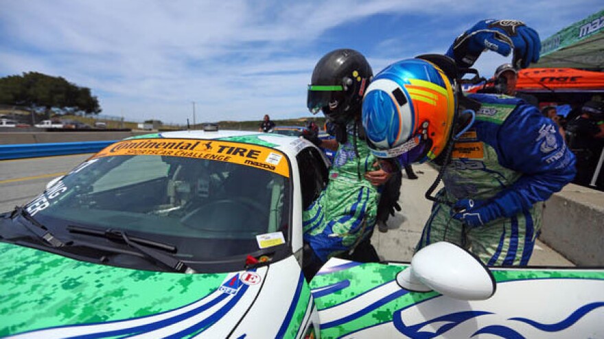 Liam Dwyer is assisted into the driver's seat of his racecar before his professional racing debut.