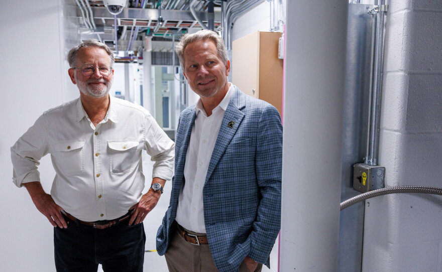 U.S. Sen. Gary Peters, left, and Michigan State University President Kevin Guskiewicz, right, visit the Facility for Rare Isotope Beams in East Lansing, Mich., on Aug. 28, 2026. The visit was the last stop on Peters' final motorcycle tour of Michigan as senator.