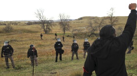 A Dakota Access pipeline protester defies law enforcement officers who are trying to force them from a camp on private land in the path of pipeline construction, Thursday, Oct. 27, 2016 near Cannon Ball, N.D.