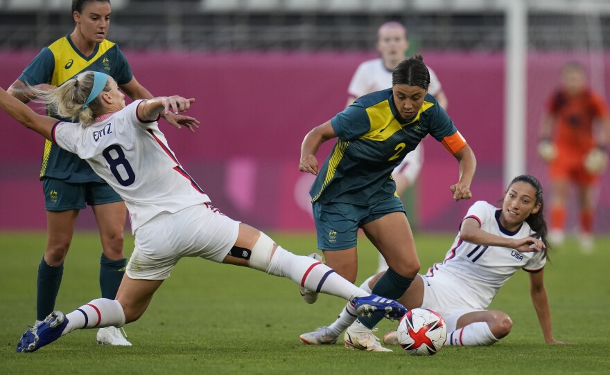 Four soccer plays seen in action during game play. #8 Team USA is seen challenging Team Austrialia #2 for possession of the ball. 