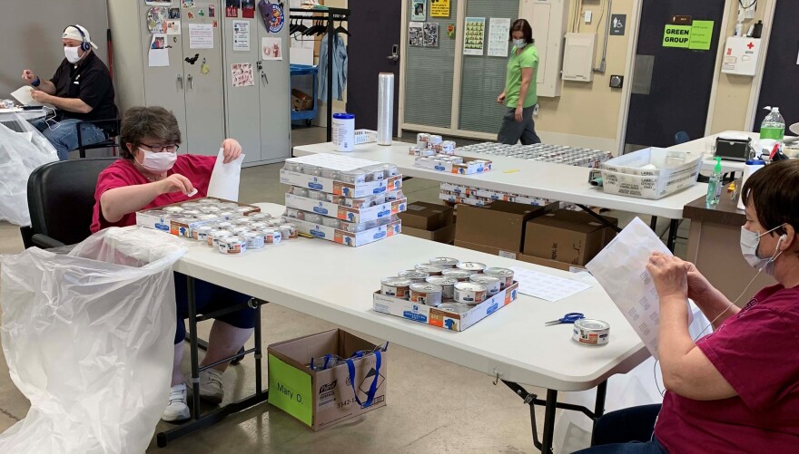 Workers at Cottonwood assemble pet food variety packs as part of their employment services.