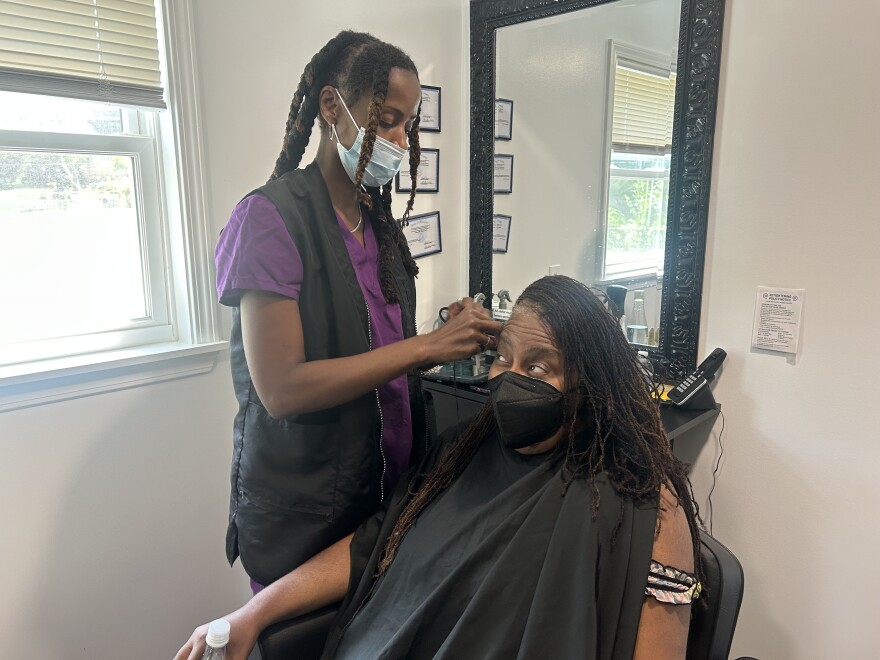 Lashaun Briggs the owner of the Your Natural Image salon gives Rhonda Beene a retwists on her dreadlocks