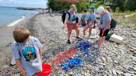 Guardians of Lake Ontario summer campers place colored rocks at the shoreline to study erosion.