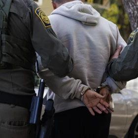 An person is detained by federal immigration enforcement agents in the 1100 block of North Wood Street in the East Village neighborhood on Friday, Oct. 24, 2025.