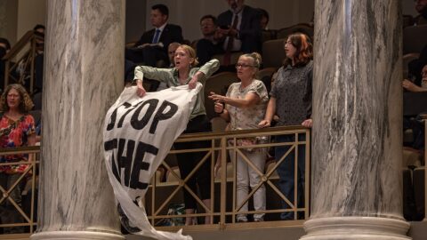 Jaeda Roth and other protestors from Abortion Access Missouri unfurl banners as the Missouri Senate passes a proposed constitutional amendment to ban abortion in May 2025.