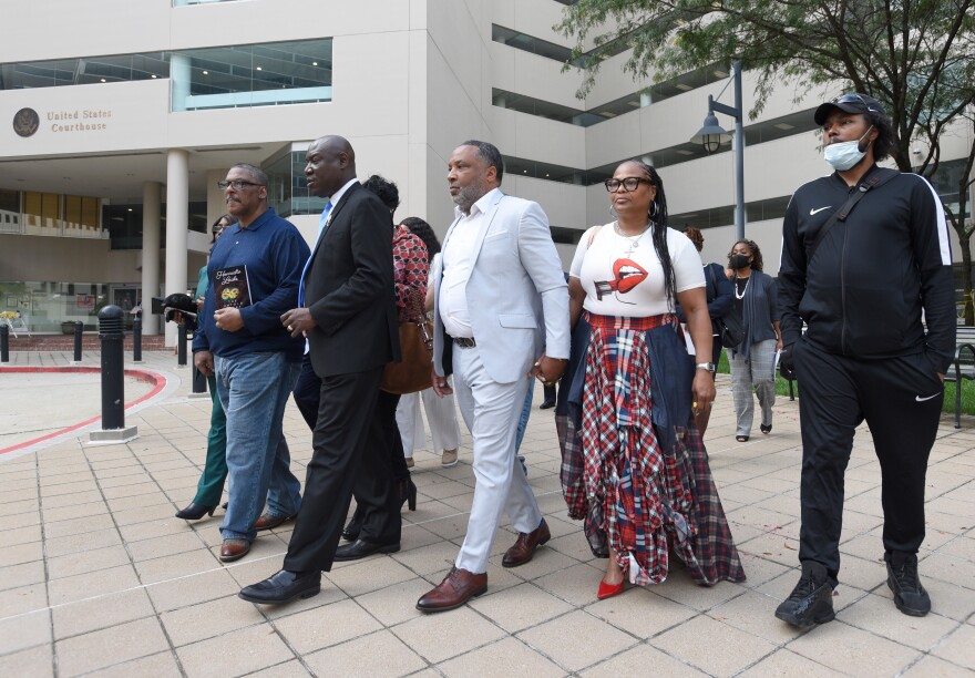 Attorney Ben Crump, second from left, walks with Ron Lacks, left, Alfred Lacks Carter, third from left, both grandsons of Henrietta Lacks, and other descendants of Lacks, outside the federal courthouse in Baltimore, Oct. 4, 2021.