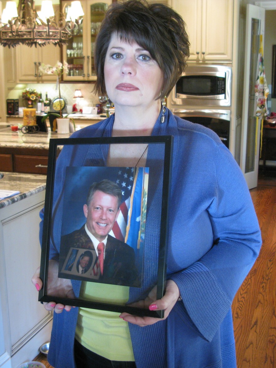 Cathy Costello, holding a picture of her late husband, Mark.