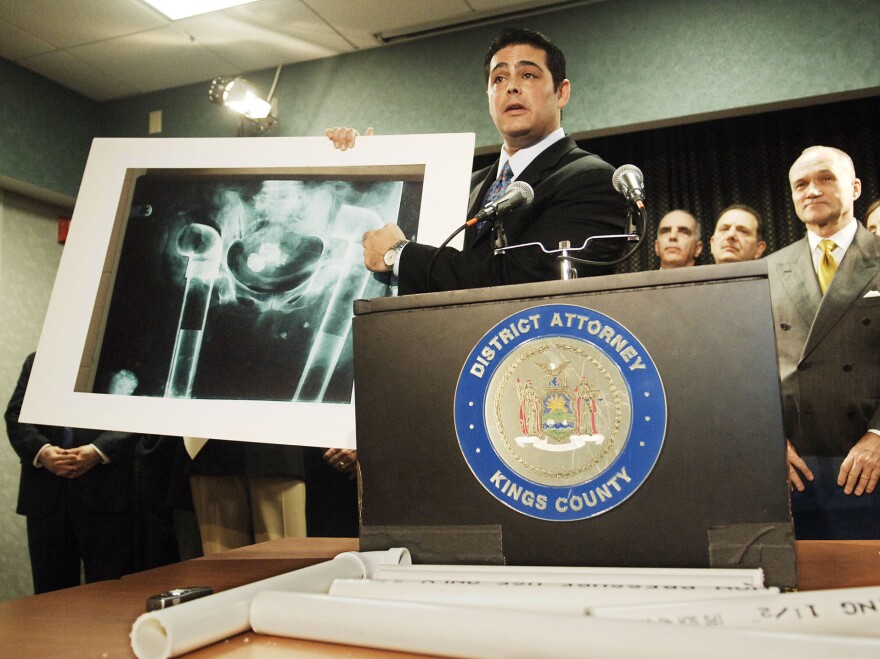 Assistant District Attorney Josh Hanshaft holds an X-ray of the pelvic area of a deceased person with PVC pipe inserted where bones should have been. The image was shown during a New York announcement of indictments of four individuals, including Michael Mastromarino, in 2006.