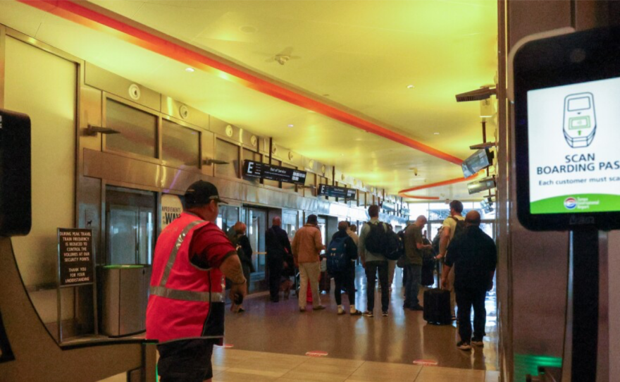 Los viajeros hacen cola para tomar el tranvía del aeropuerto.