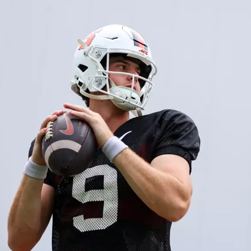 Quarterback Steve Angeli (9, Black) readies to throw in a preseason practice.