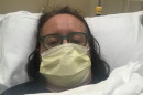 Close up of Christina Ray Stanton in a hospital bed wearing a face mask.