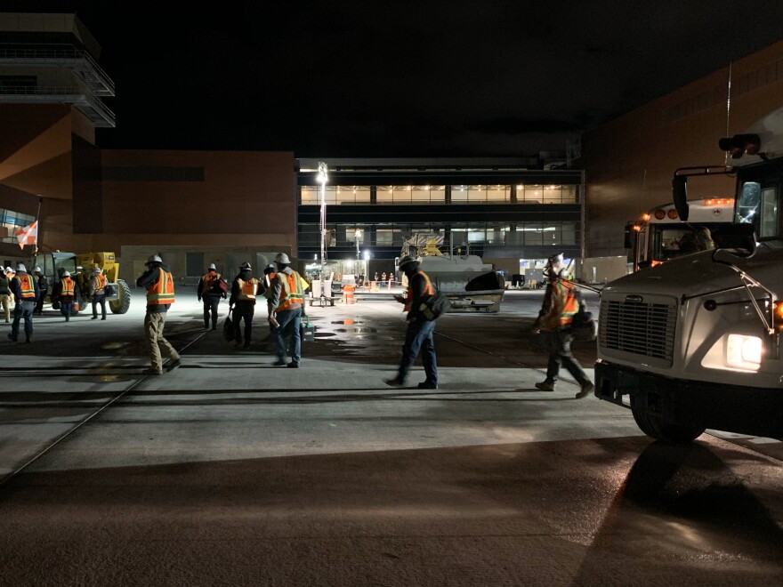 RK workers depart a bus on their way to the job site at a new airport under construction in Salt Lake City. [Yuki Noguchi / NPR]