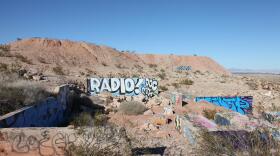 Wall in the middle of the desert with "radio" spray painted on it