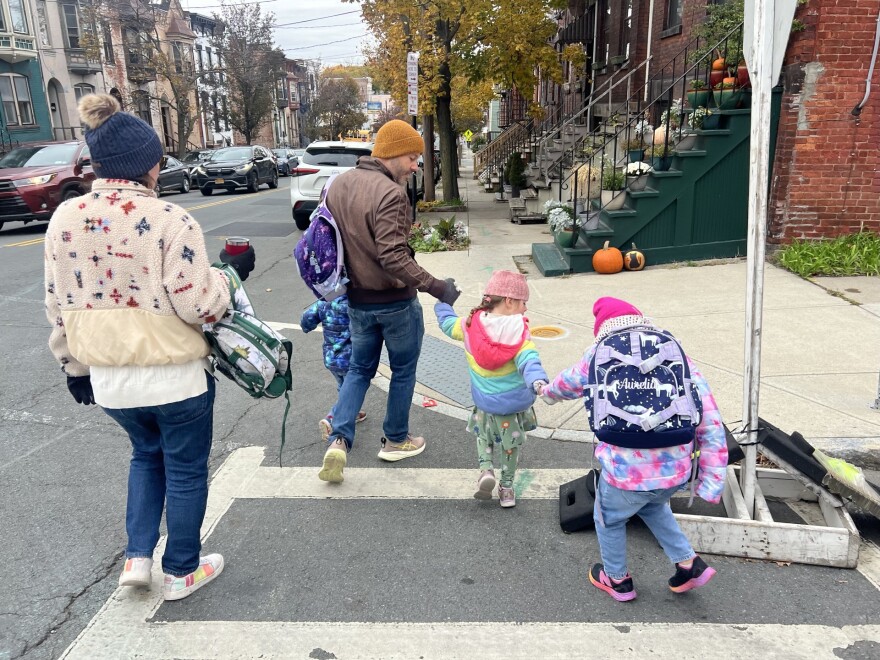 Julia Battista (far left) and Jason DiNovi (middle) cross the streets with children, keeping an eye out obstructions and oncoming traffic.