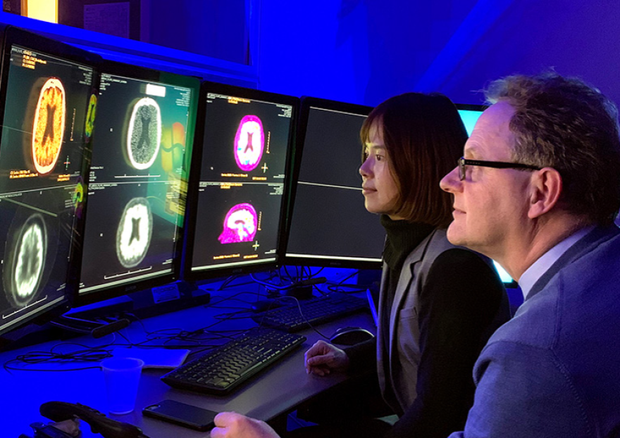 Drs. Anton Porsteinsson and Lin look at research brain PET scans at the University of Rochester Medical Center, circa 2018.