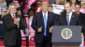 President Donald Trump, center, gives a thumbs up as he shows his support for congressional candidates Rep. Ted Budd, right, and Mark Harris, left, during a campaign rally in Charlotte in October.