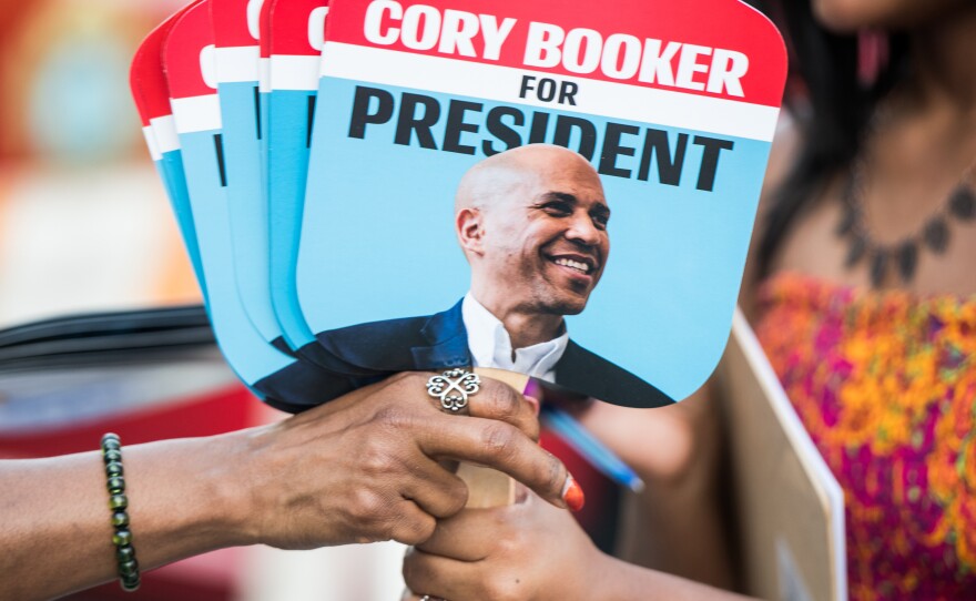 Supporters of Sen. Cory Booker share fans with the candidate's face. The 2020 presidential field, which includes at least three black candidates, is the most racially progressive ever.