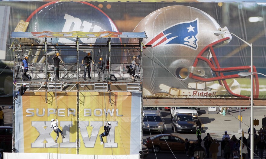 Zip-line riders finish their ride down the line over part of the Super Bowl Village on Thursday in Indianapolis. The New England Patriots are scheduled to face the New York Giants in NFL football's Super Bowl XLVI Feb. 5.