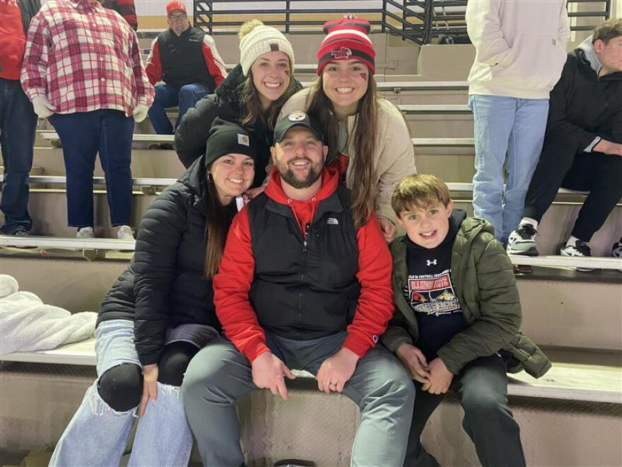 A family poses for a photo at a football game