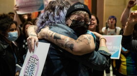 Minnesota State Representative Leigh Finke (C) is embraced by a supporter before the Minnesota Senate introduces the Trans Refuge Bill at the State Capitol Building in Saint Paul, Minnesota..