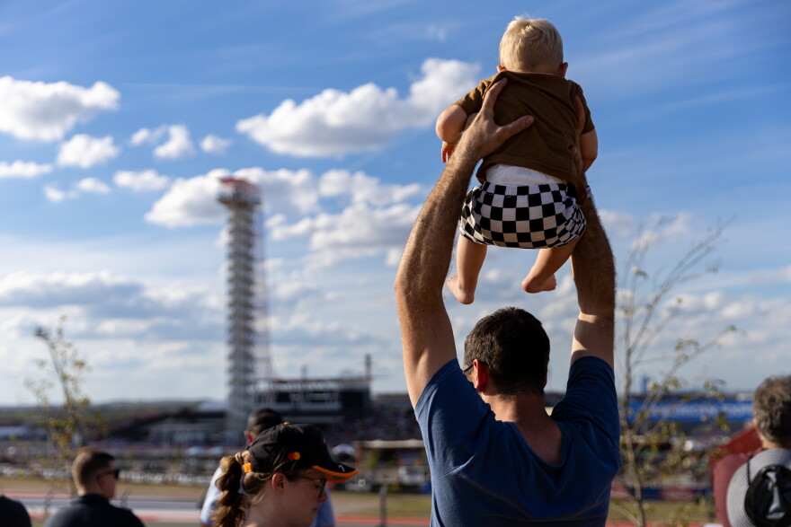 A man holds his baby at the U.S. Grand Prix at the Circuit of the Americas on Saturday.